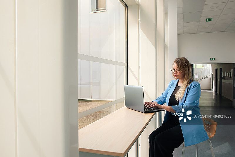 办公室中的商务女人：成熟女人的肖像，女性职业，经理，决策，使用笔记本电脑工作的女人图片素材