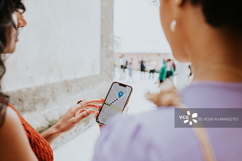两个女人使用在线地图App讨论步行路线图片素材