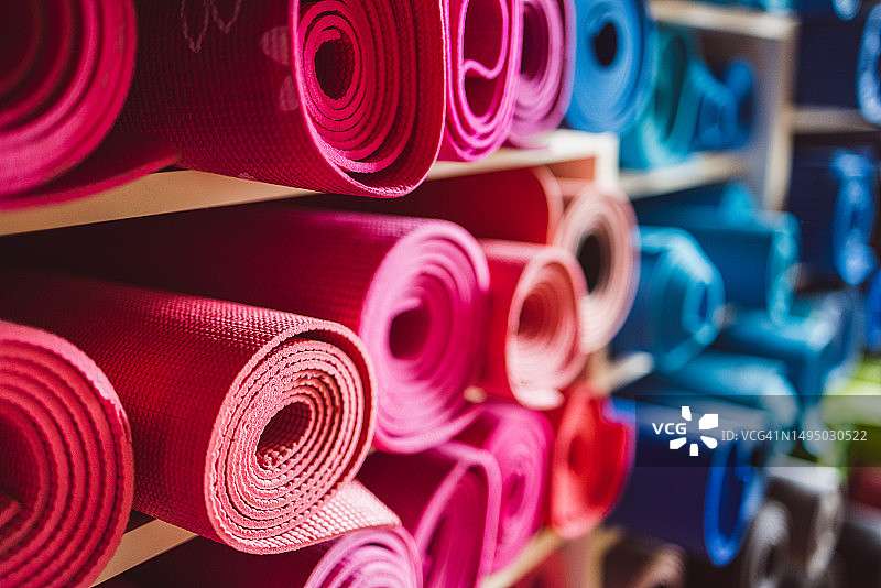 瑜伽馆货架上卷起的粉色瑜伽垫图片素材