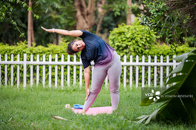 年轻女人在公园做瑜伽和晨练图片素材