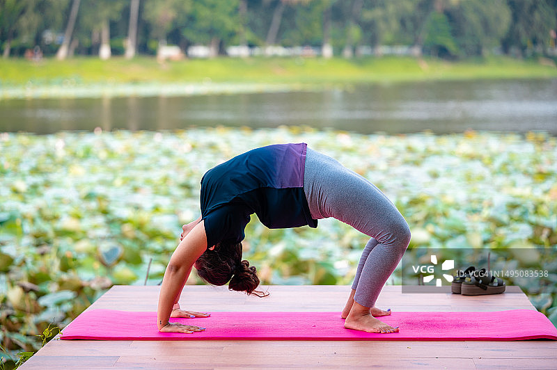 女人练习上弓式瑜伽姿势图片素材