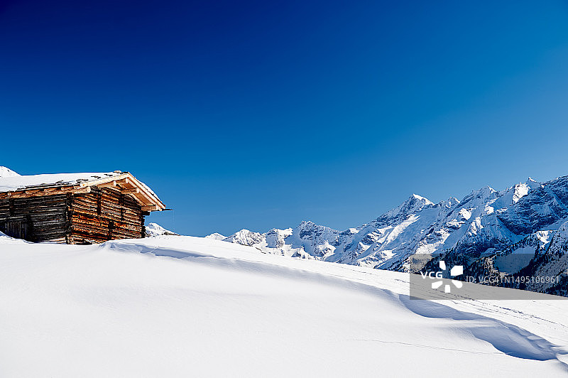 雪山顶峰上的孤独小木屋图片素材