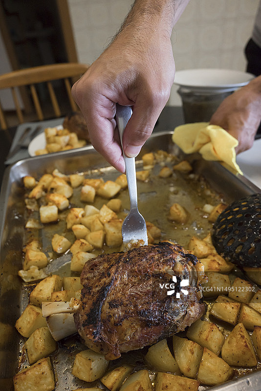 正在提供烤猪肘的匿名人士图片素材