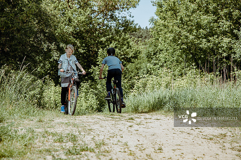 两名男人在乡间小路上骑自行车图片素材