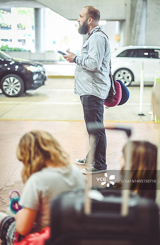 在机场等车的男人，手持手机图片素材