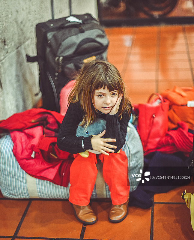 疲惫的年轻女孩在机场等待，行李延误图片素材