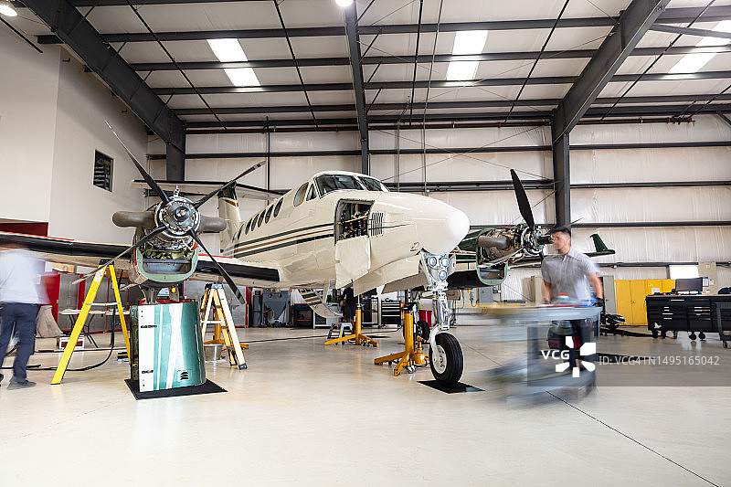 机械师正在维修涡轮螺旋桨飞机图片素材