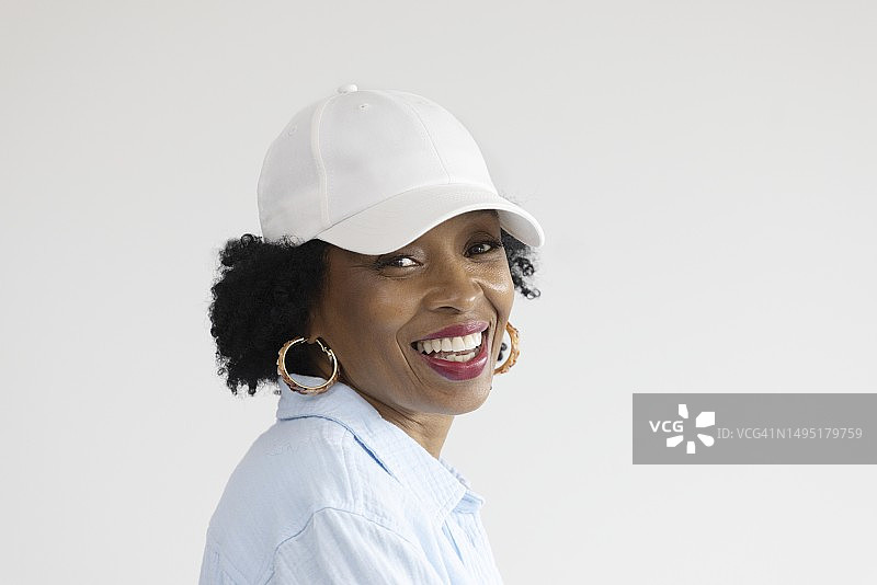涂着红色口红、头戴白色棒球帽的中年非裔美国女性肖像图片素材