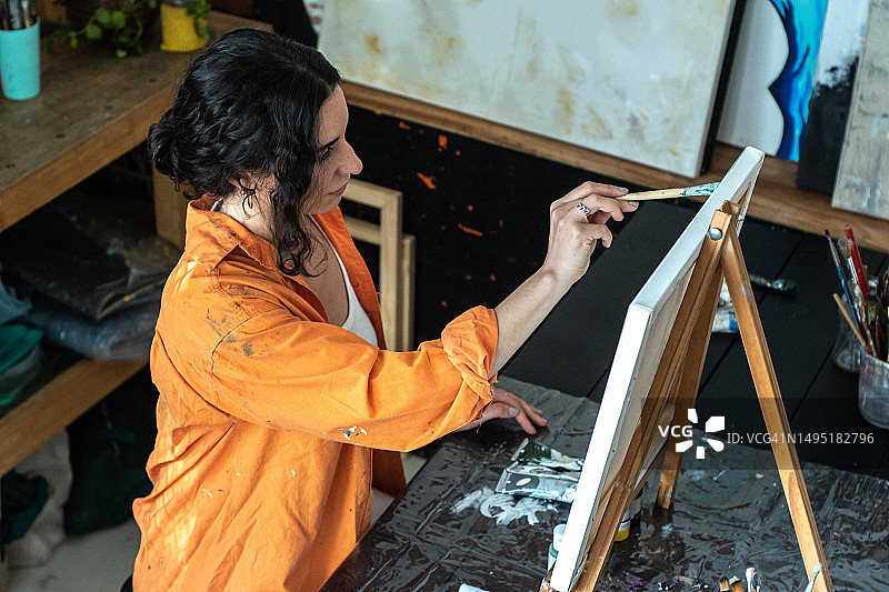 中年妇女在家在画布上绘画图片素材