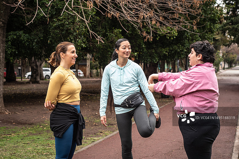 女人们在公园里边伸展边聊天图片素材