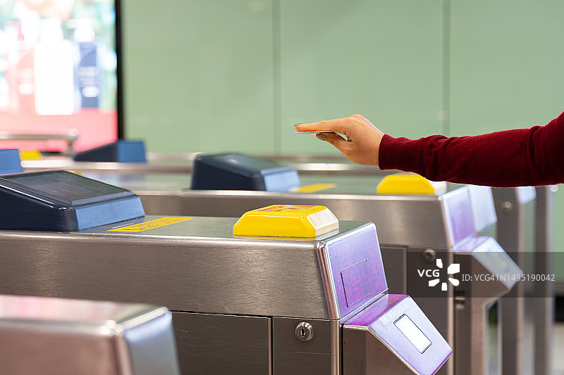 特写：女人的手在地铁站入口处触摸代币卡图片素材