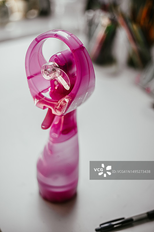 白色桌面上粉色塑料小手摆件图片素材