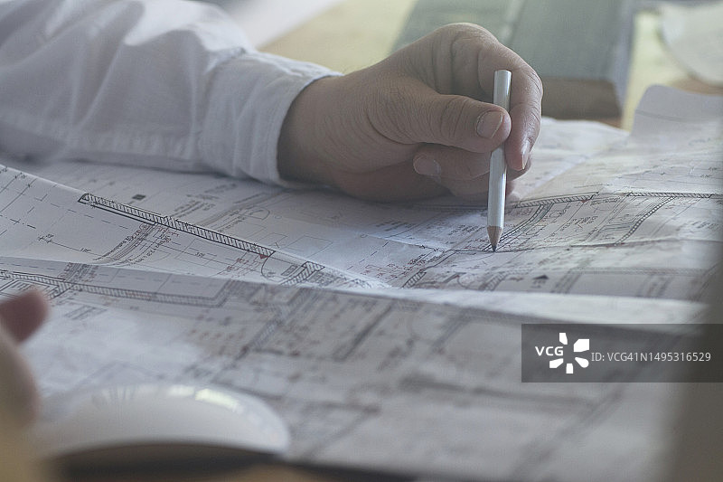 办公室里商人用铅笔绘制蓝图图片素材