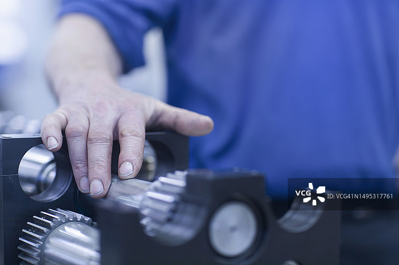 成熟工程师触摸金属备件的截面图图片素材
