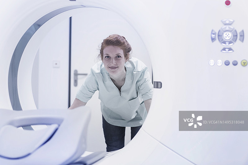 微笑的护士正在查看CAT扫描仪图片素材
