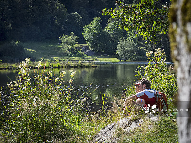 山地自行车骑行者在湖边休息图片素材