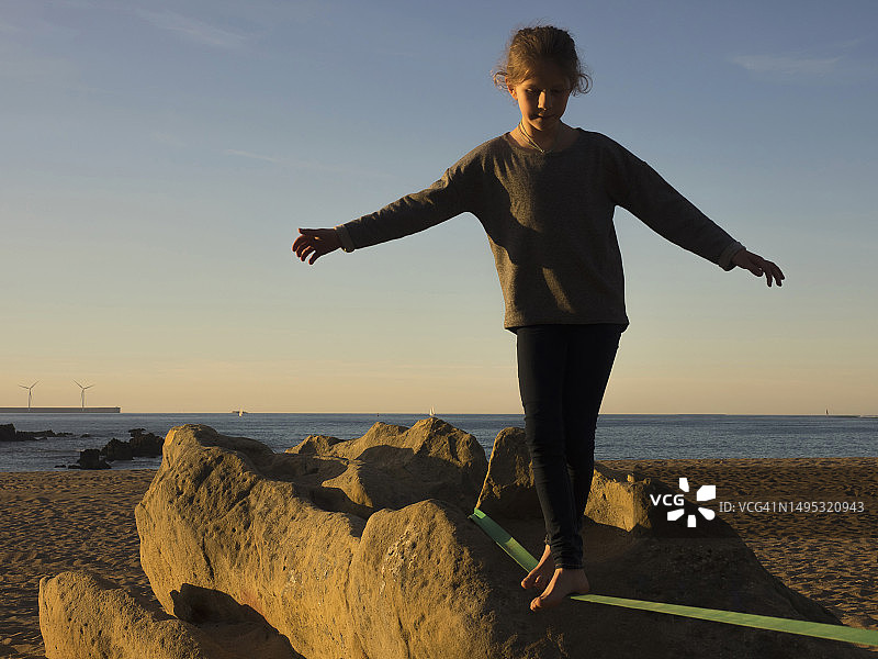 西班牙北部沙滩上玩扁带的女孩图片素材