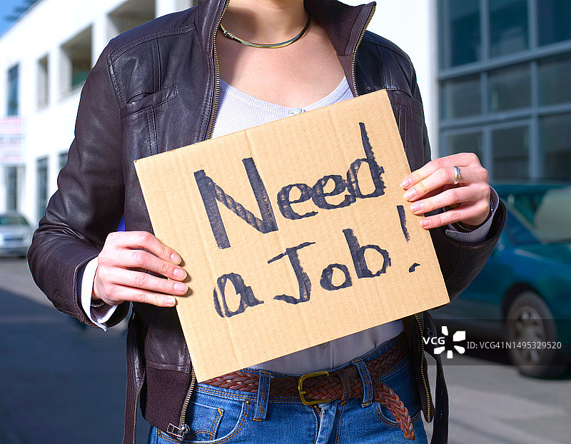 女人举着“需要工作”的牌子图片素材