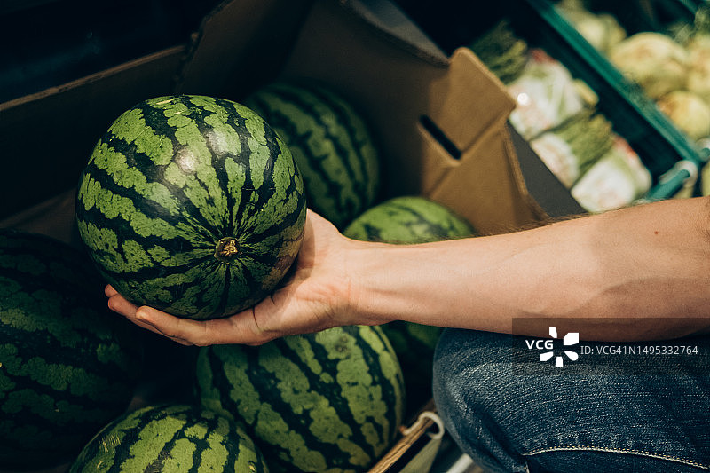 男人在商店挑选西瓜图片素材
