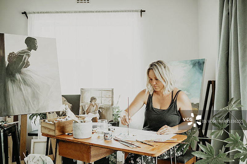 女性在工作室、家中或房子里绘画和创意艺术，使用画笔、颜料和画布。艺术家和轻松的画家在工作室里有设计天赋图片素材