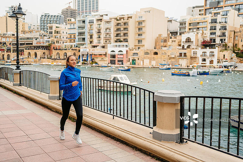 年轻女子在马耳他圣朱利安长廊跑步图片素材