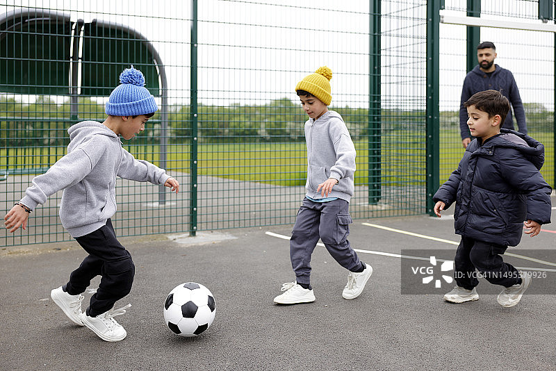 和父亲一起踢足球的儿童图片素材