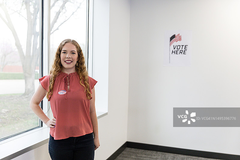 在投票站对着镜头微笑的年轻女志愿者图片素材