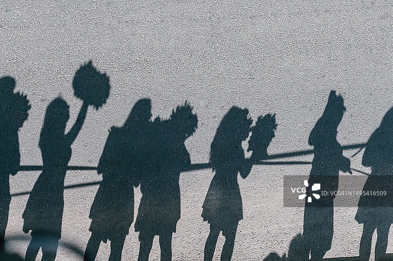 女粉丝群体迎接业余铁人三项运动员的剪影图片素材