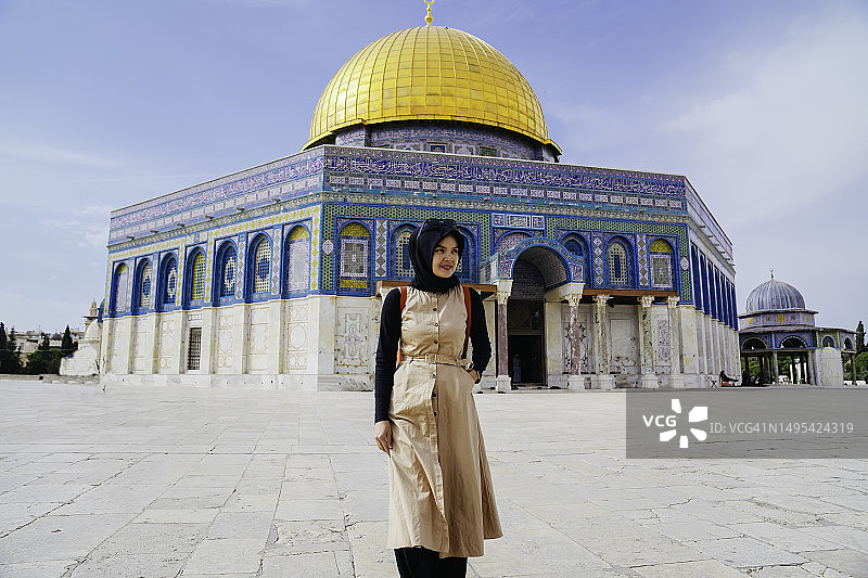 以圆顶清真寺为背景的亚洲穆斯林妇女图片素材