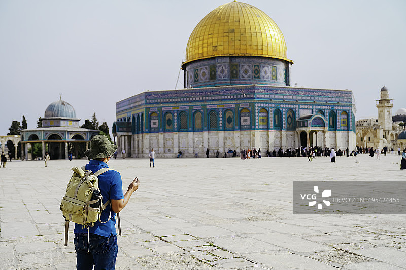 亚洲男人在圆顶清真寺背景下祈祷图片素材