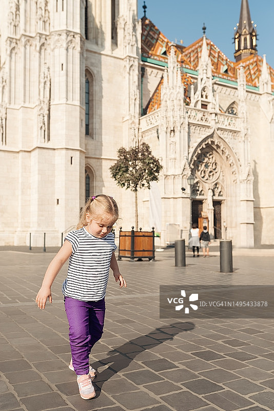 小女孩走在匈牙利布达佩斯马蒂亚斯教堂前的广场上图片素材