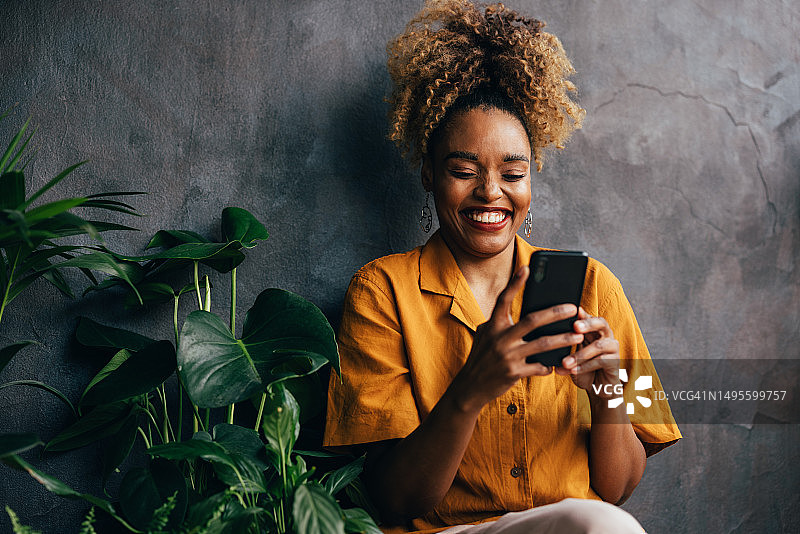 快乐美丽的职场金发女人在放松时用手机发短信图片素材