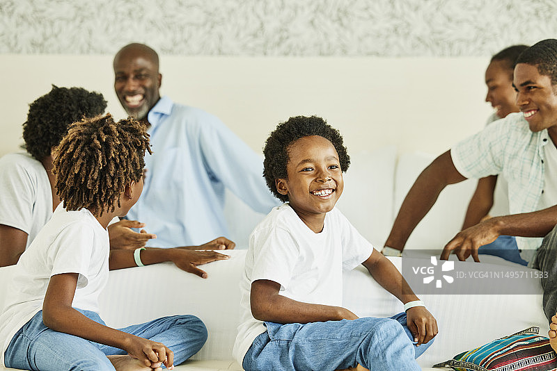 笑容满面的小男孩与家人在酒店床上放松图片素材