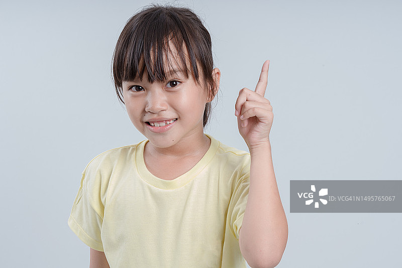 快乐的女孩指着一个想法，白色背景分离图片素材