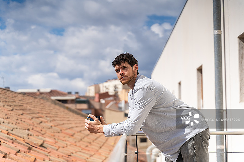 在阳台上喝咖啡放松的商务男士图片素材