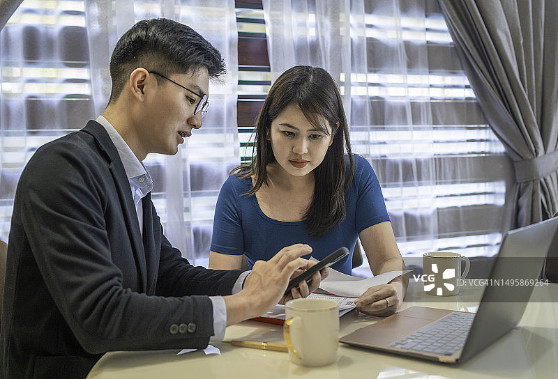 财务顾问在家中使用笔记本电脑为客户处理文书工作图片素材