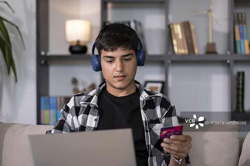 青年男子使用信用卡在线购物图片素材