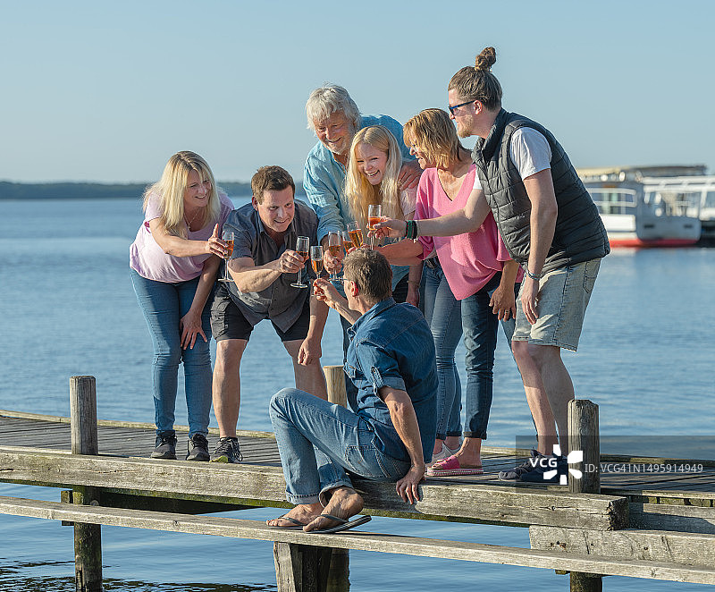 一群中年人在湖边码头举杯庆祝图片素材