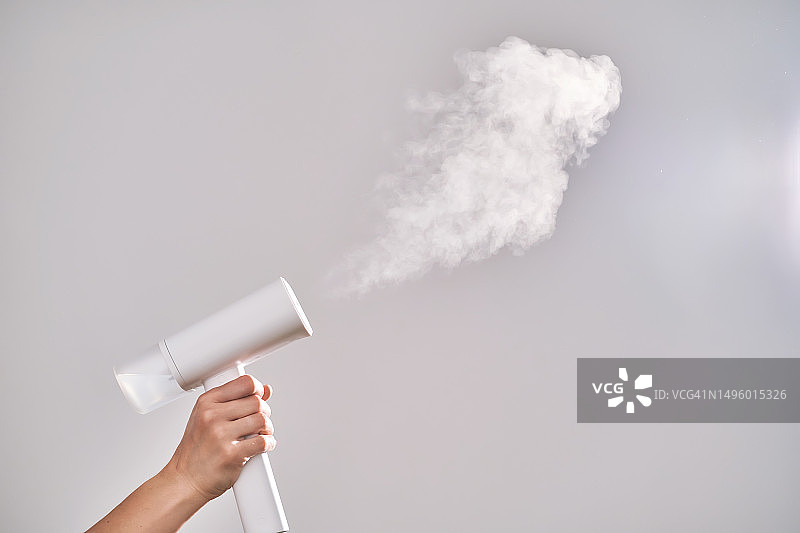 女人手持蒸汽机，大量蒸汽图片素材