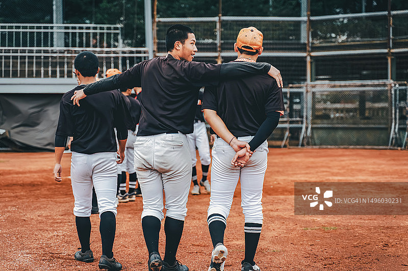 棒球运动员在训练结束后互相鼓励的背影图片素材