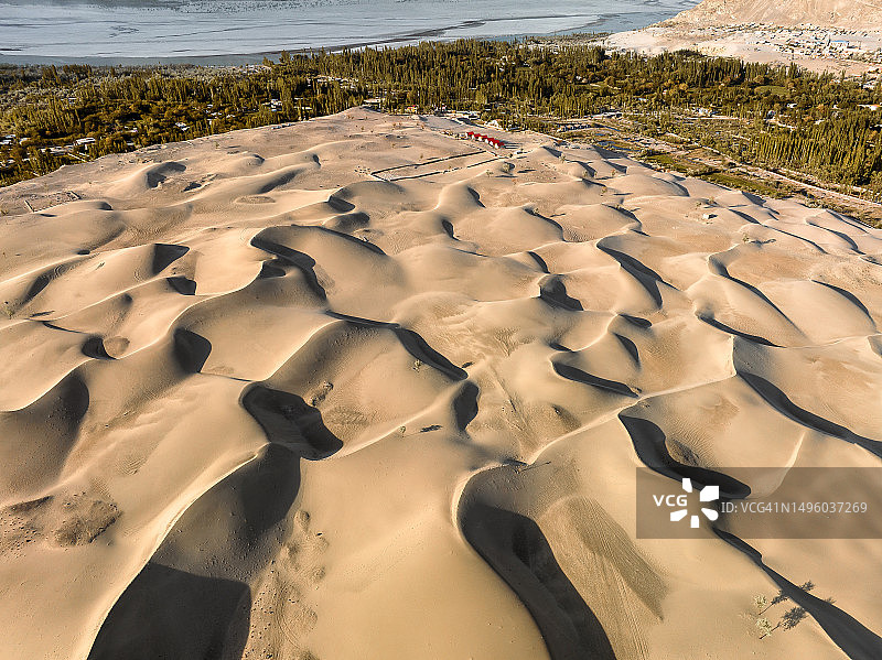 巴基斯坦北部斯卡杜喀喇昆仑山脉卡特帕纳冷沙漠沙丘的无人机日落景观图片素材