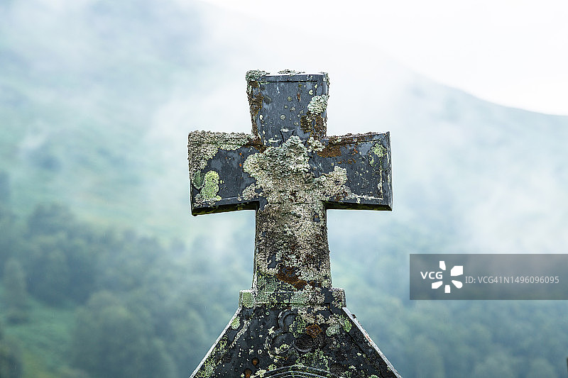 覆盖着苔藓和地衣的墓碑，背景是雾蒙蒙的山，苏格兰图片素材