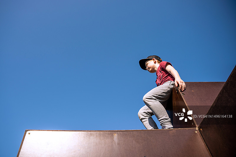 男孩清晨坐在跑酷运动场上图片素材