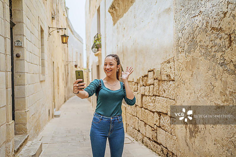 年轻女子在马耳他姆迪纳进行视频通话图片素材