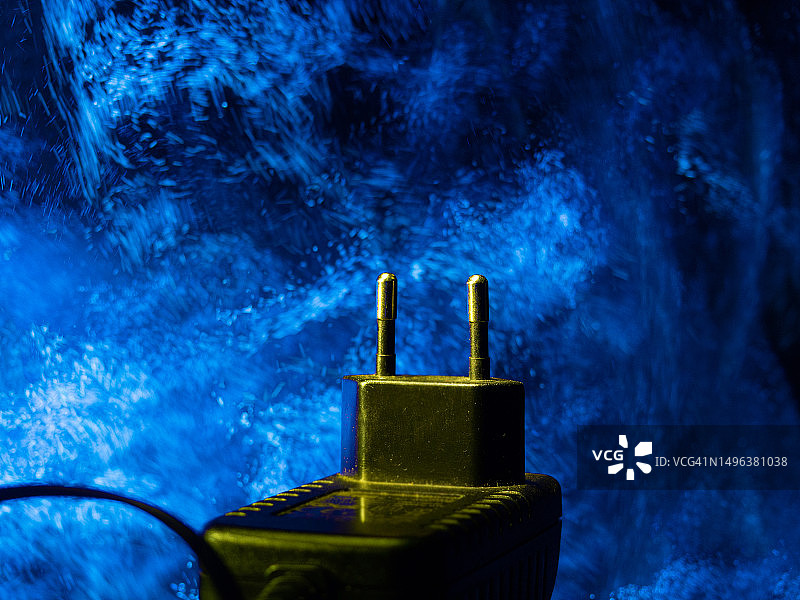 蓝色背景上的电源插头电缆，能源消耗概念图片素材