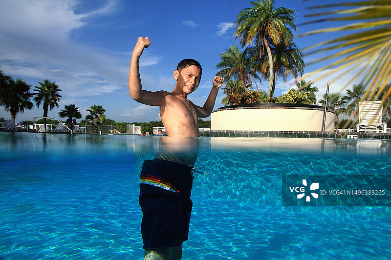 游泳池中青少年男孩的半水下视角图片素材