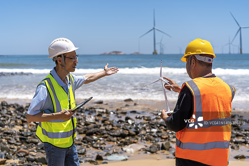 两名亚洲男工程师正在讨论风力发电图片素材