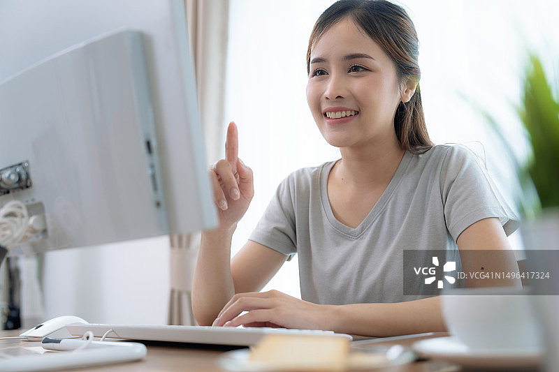 快乐的亚洲年轻女性在家工作和在线会议图片素材