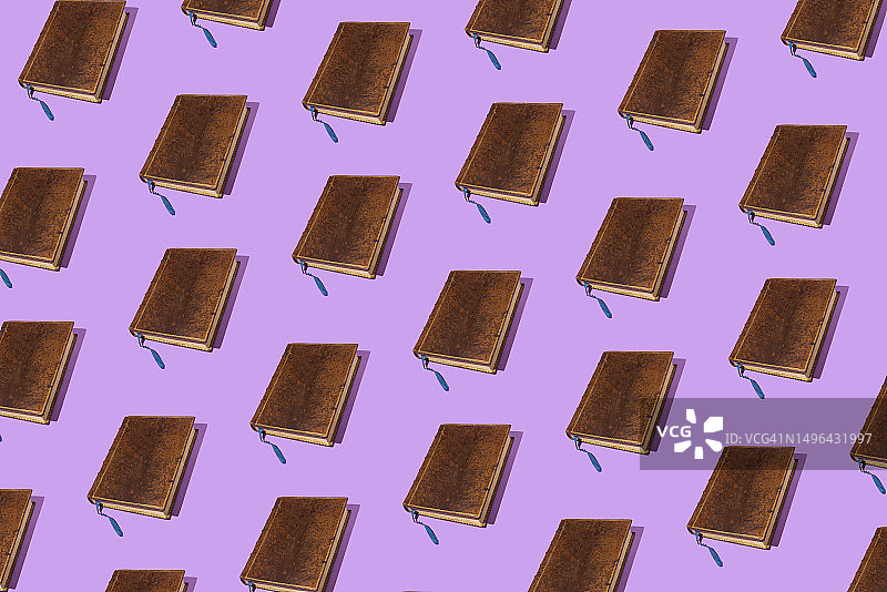 紫色背景上的旧棕色皮革书本图案图片素材