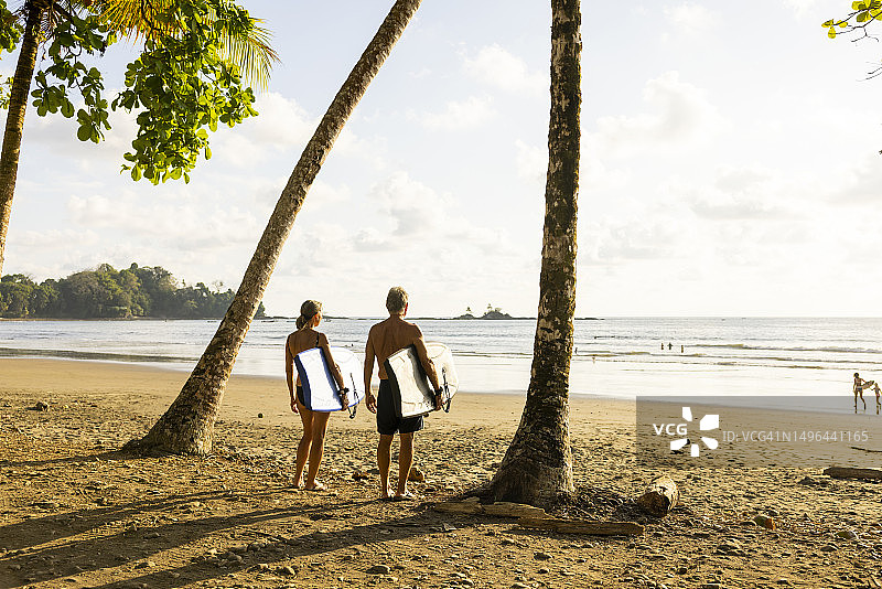 老年夫妇拿着趴板准备在海中玩耍图片素材